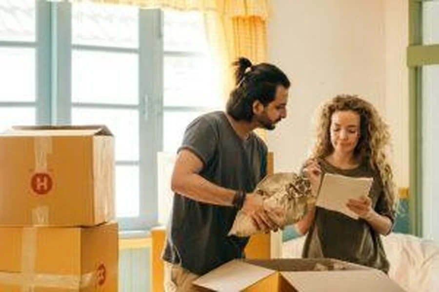 Couple unpacking boxes together.